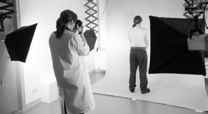 Medische fotograaf maakt een foto van een mannelijke rug in een fotostudio